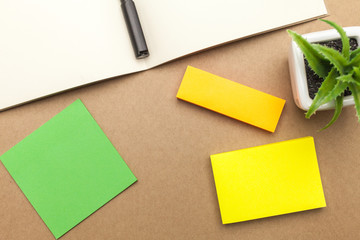 Blank paper,book,pen and plant on brown background