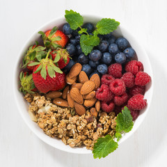 muesli, almonds and fresh berries in a bowl, top view
