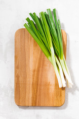 wooden cutting board and green onions, top view