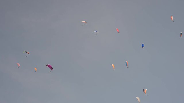 Upwards view of people paragliding up in the sky.