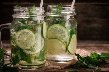 detox water with a lemon, lime and mint on a wooden table