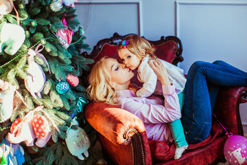 Mom kisses her little daughter