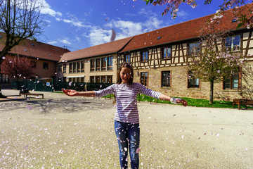 Fototapeta na wymiar Teenage girl playing with falling petals on the sun