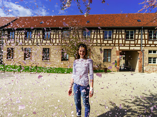 Fototapeta na wymiar Teenage girl playing with falling petals on the sun