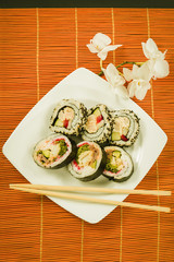 Sushi on a plate and orchid 
