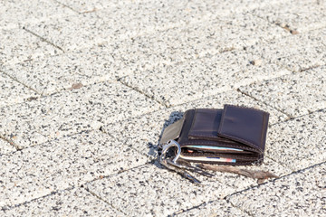 Brown leather wallet on concrete sidewalk