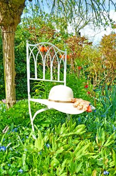 Gartenidylle: Stuhl, Sonnenhut und Gartenhandschuhe