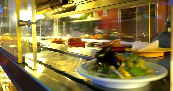 4k Various dishes on plates on conveyor belt in japanese restaurant