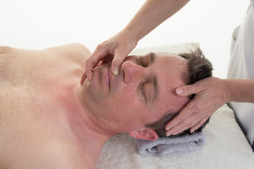 Therapist female applying pressure with thumbs on forehead.