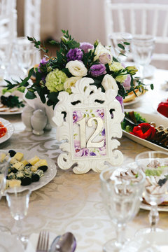 Vintage table number in frame at white wedding reception