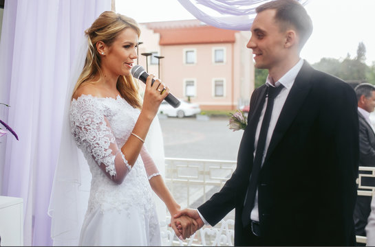 Beautiful blonde bride & groom taking vows at wedding ceremony