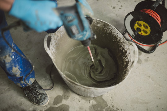 Bricklayer mixing cement in bucket