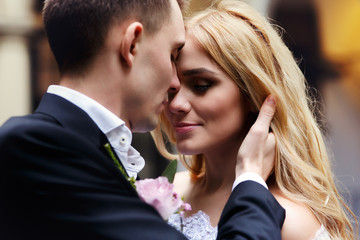 Sensual romantic newlywed couple hugging in italian street closeup