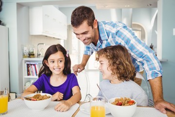 Obraz na płótnie Canvas Happy man with children having breakfast