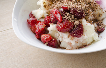 Semolina pudding served with fresh fruit strawberries and sprinkled with grated chocolate