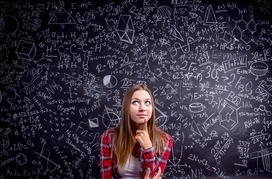 Student against a big blackboard with mathematical symbols - Powered by Adobe