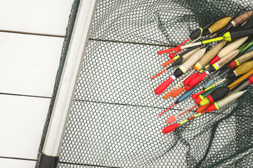 Fishing floats are located on grid nets for catching fish on a wooden surface in white © livarnava