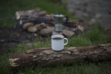 Obraz premium Teenager sitting near a fire in camping and watching map.