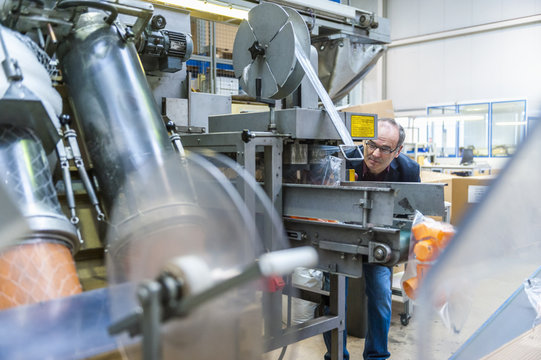 Manager checking packaging of goods in plastics factory