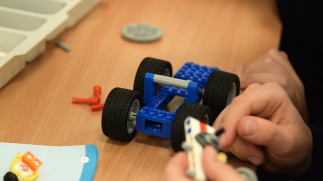Close-up shot of two pupils working with meccano set to make a robot. Robotics at school