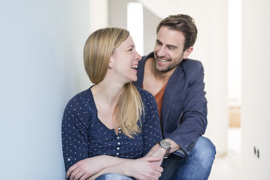 Laughing couple holding hands in their new freehold apartment