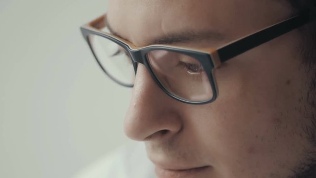 Close Up Portrait Of Young Business Man Wearing Eye Glasses With Glare Side View