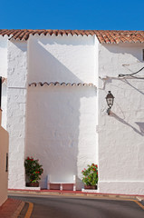Minorca, isole Baleari, Spagna: una panchina davanti alla chiesa del villaggio di pescatori di Es Fornells il 10 luglio 2013