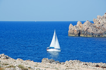 Minorca, isole Baleari, Spagna: una barca a vela all'ingresso del porto del villaggio di pescatori...