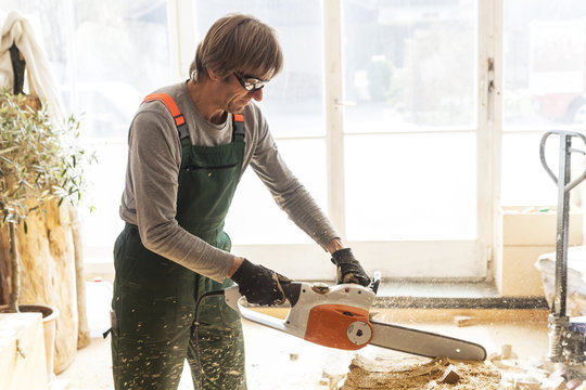 Wood carver in workshopworking on wood for a sculpture with a chainsaw