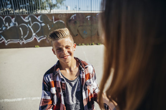 Portrait of smiling teenage boy face to face with his girlfriend