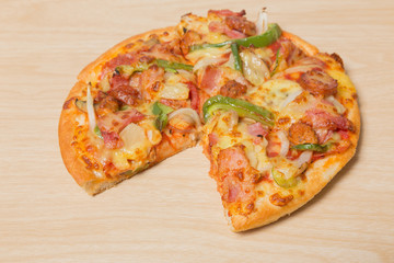 Pizza with sliced vegetables on wood