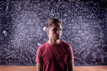 Student against a big blackboard with mathematical symbols