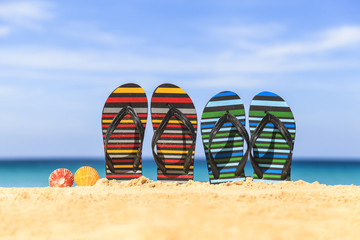 Naklejka premium Flip flops on the sandy beach