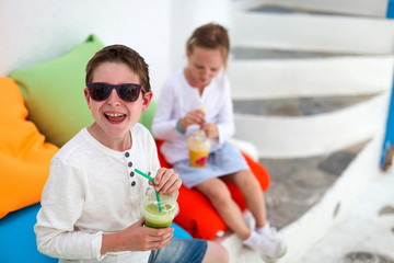 Two kids drinking smoothies outdoors