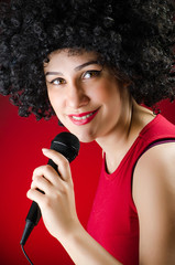 Woman with afro hairstyle singing in karaoke