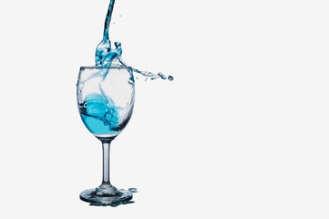 Cocktail  splash into wine glass isolated on white background.