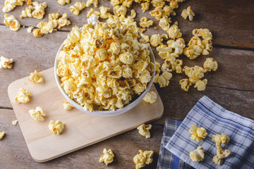 bowl of popcorn on the wooden table, selective focus