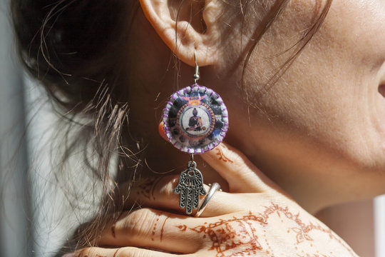 Woman wearing original earings and mehndi on her hand