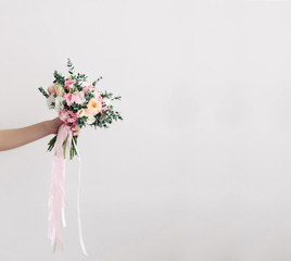 Beautiful wedding bouquet in hands of the bride. Peony rose, cotton, roses. Pink and Peach. Trendy and modern wedding flowers. Ideal photo for commercial. Space for your logo - 108982949