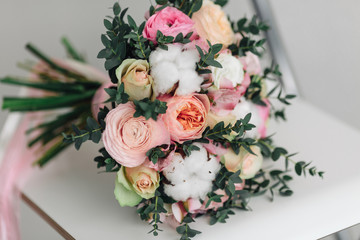 Beautiful wedding bouquet in hands of the bride. Peony rose, cotton, roses. Pink and Peach. Trendy and modern wedding flowers. Ideal photo for commercial. 