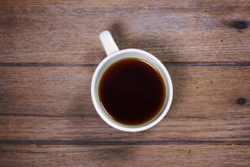 Hot coffee Americano in cup on wooden table.