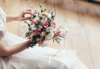 Beautiful wedding bouquet in hands of the bride. Peony rose, cotton, roses. Pink and Peach. Trendy and modern wedding flowers. Ideal photo for commercial. 