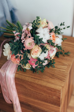 Beautiful wedding bouquet on wooden space. Peony rose, cotton, roses. Pink and Peach. Trendy and modern wedding flowers. Ideal photo for commercial. 
