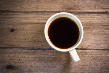 Hot coffee Americano in cup on wooden table.