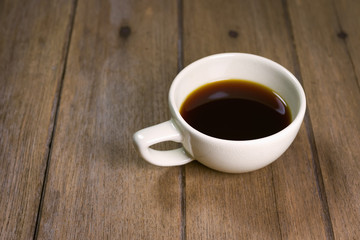 Hot coffee Americano in cup on wooden table.