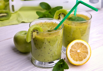 Green smoothie with mint and fruits on the wooden background