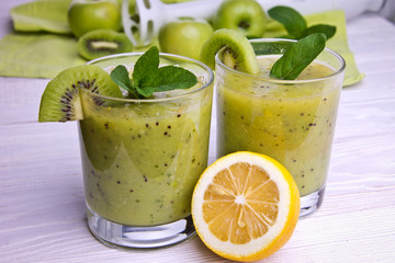 Green smoothie with mint and fruits on the wooden background