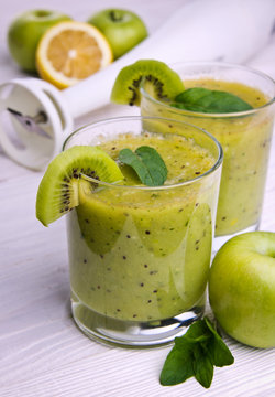 Green smoothie with mint and fruits on the wooden background