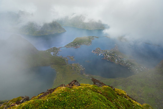 Scenic landscape of Lofoten islands: peaks, lakes, clouds and houses. Reine village, rorbu, reinbringen