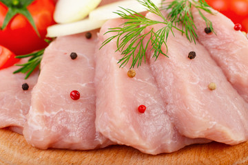 Raw pork steaks with a sprig of dill